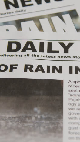 Vertical-Video-Of-Newspaper-Headline-Discussing-Extreme-Weather-Conditions-And-Global-Warming-Crisis